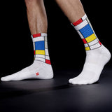 White socks with colorful Mondrian pattern worn by a person on a black background thumbnail