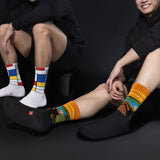Two people wearing colorful socks against a black background