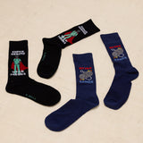 Two pairs of socks with superhero and gaming designs on a beige background thumbnail