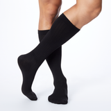 Front profile of a man wearing Dr. Scholl's black knee high compression socks. thumbnail