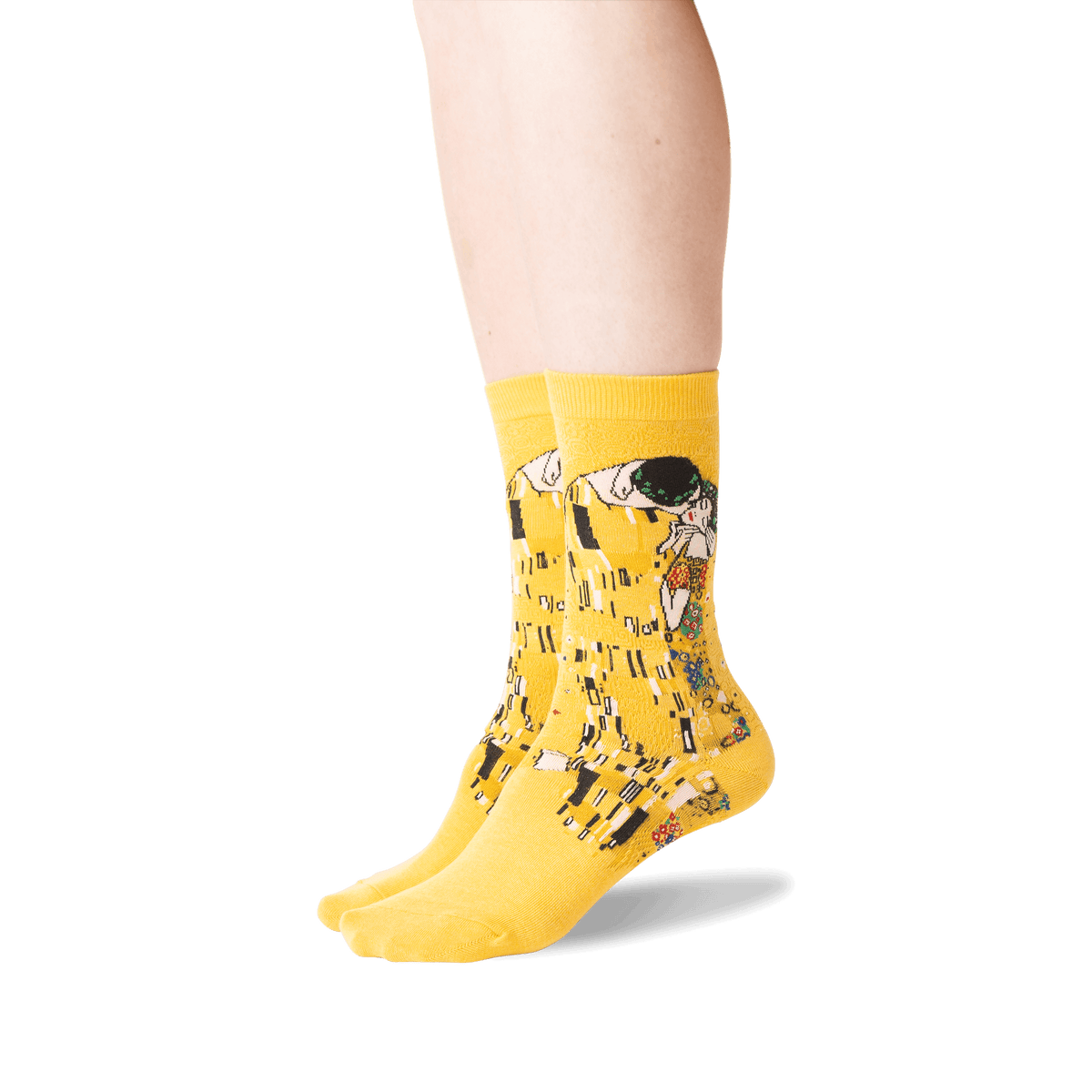 A pair of bright yellow crew socks with a detailed art print of Gustav Klimt's 'The Kiss' on the sides, shown on a person's feet against a plain white background.