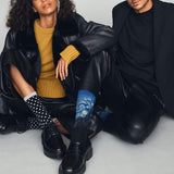 Two people sitting side by side wearing stylish outfits with socks. thumbnail