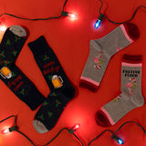 Two pairs of festive socks on a red background with Christmas lights. thumbnail