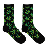 A pair of black crew socks with an all-over green leaf pattern, displayed against a solid white background. thumbnail
