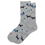 A pair of heather gray crew socks featuring an all-over pattern of various dogs in navy blue and black Hanukkah-inspired outfits, with one sock showing the red text 'HOTSOX' near the toe.