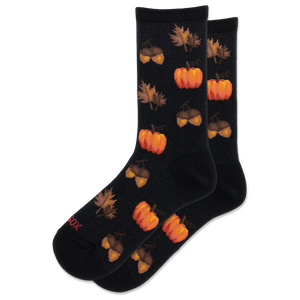 A pair of black crew socks with a repeating autumn pattern of orange pumpkins, acorns, and brown leaves, shown on a plain white background.
