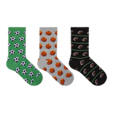 Three pairs of crew socks displayed side by side on a plain white background. The left pair is green with black and white soccer ball patterns, the middle pair is gray with orange basketball patterns, and the right pair is black with brown football patterns and thin green stripes.