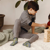 Child playing with wooden blocks on a carpeted floor