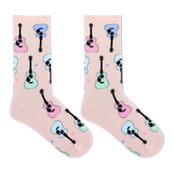 A pair of light pink crew socks with a repeating pattern of cartoon guitars in pastel pink, blue, and mint green, displayed on a clean white background.