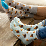 Two pairs of socks with ice cream cone pattern on a wooden surface. thumbnail