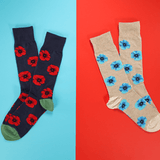 Two pairs of socks with floral patterns on a two-tone blue and red background.