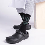 Person wearing black clogs and 'YES CHEF' socks on a white background thumbnail