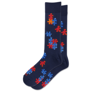 A pair of navy blue crew socks featuring a pattern of red and blue puzzle pieces, displayed against a solid white background.