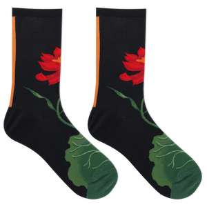 A pair of black crew socks featuring a red lotus flower and green leaf design, with a vertical orange stripe near the cuff, shown on a plain white background.