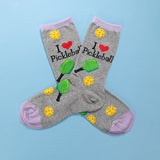 Gray socks with pickleball designs and text on a blue background
