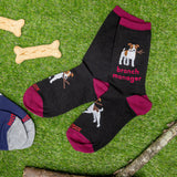 Black socks with dog illustrations and 'branch manager' text on a grass background with dog bones and a branch. thumbnail
