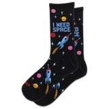 A pair of black crew socks with a colorful space-themed pattern featuring blue rockets, pink and yellow planets, and the text 'I NEED SPACE' on a white background.