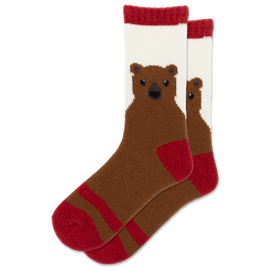 A pair of crew socks featuring a knitted brown bear face on a white background with red cuffs, heels, and toes, shown against a plain white background.