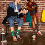 Two people sitting on a bench with trophies, wearing colorful socks.