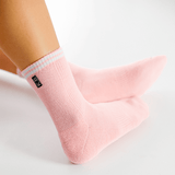 Pink socks with a brand logo on a light gray background thumbnail