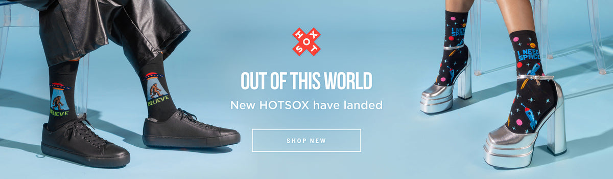 A promotional banner for HOTSOX socks showing three pairs of patterned crew socks worn with different footwear on a light blue studio background. The center text reads 'OUT OF THIS WORLD New HOTSOX have landed' with a 'SHOP NEW' button below.
