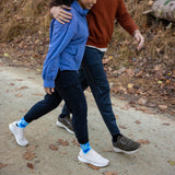 Two people walking together on a path with autumn leaves around thumbnail