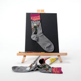 Gray sock with a colorful design on an easel with art supplies thumbnail