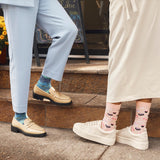 Two people standing on steps, wearing colorful socks and different types of shoes. thumbnail