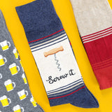 THhree pairs of socks with different alcohol designs on a yellow background thumbnail