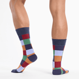 Colorful checkered socks worn by a person on a white background