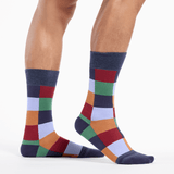 Colorful checkered socks worn by a person on a white background thumbnail