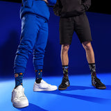 Two people wearing colorful socks with famous painting designs on a blue background thumbnail