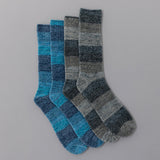 Two pairs of checkered socks in blue and gray on a gray background thumbnail