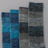 Two pairs of checkered socks in blue and gray on a gray background