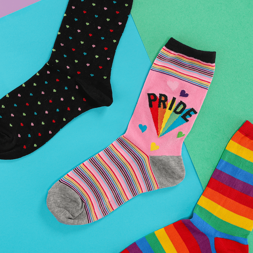 Colorful socks with rainbow patterns and 'PRIDE' text on a multicolored background