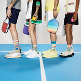 Four people standing on a pickleball court with colorful equipment and socks.