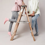 Two people using a wooden step ladder against a plain background thumbnail