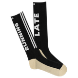 A pair of black and beige crew socks with 'RUNNING LATE' text and stripes. thumbnail
