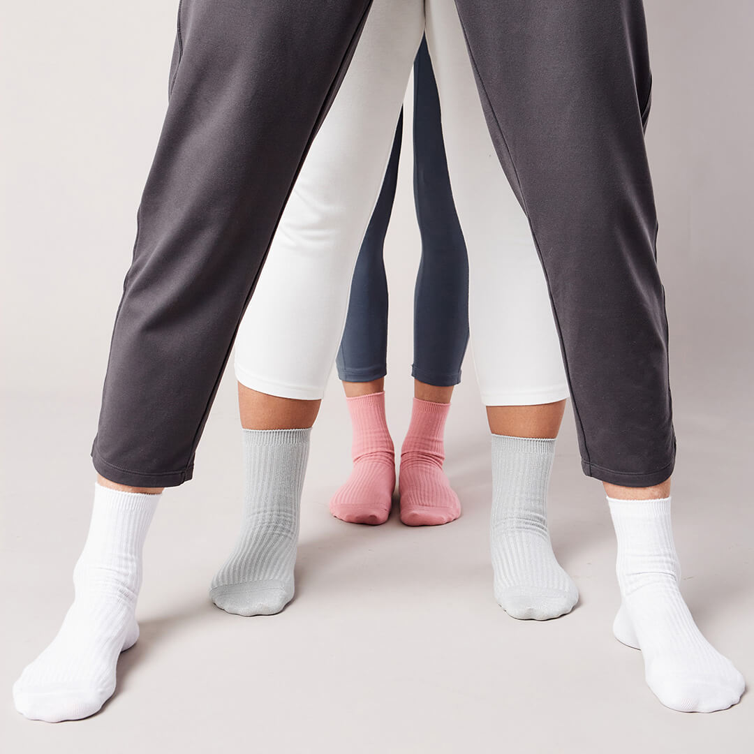 Three pairs of pants worn by different people on a plain background