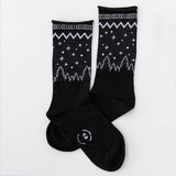 Black socks with white patterns on a light gray background