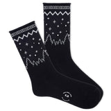 A pair of K.Bell women's roll-top crew socks with a winter sparkle design, featuring star patterns on a black background. thumbnail