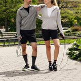 Two people walking with jump ropes in a park setting