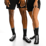 Two people wearing black socks with visible branding on a white background thumbnail